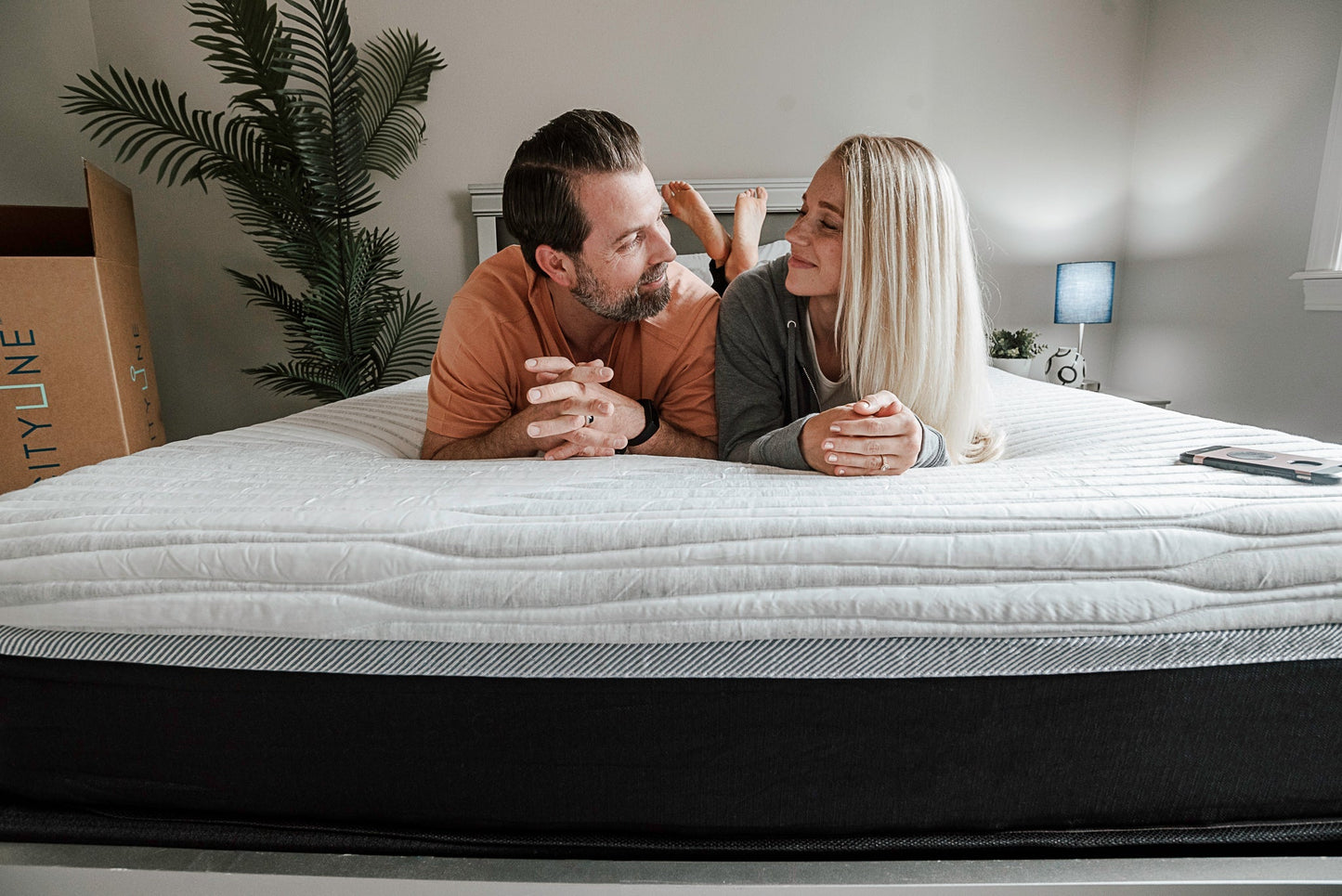 Man and Woman resting on mattress looking at each other lovingly